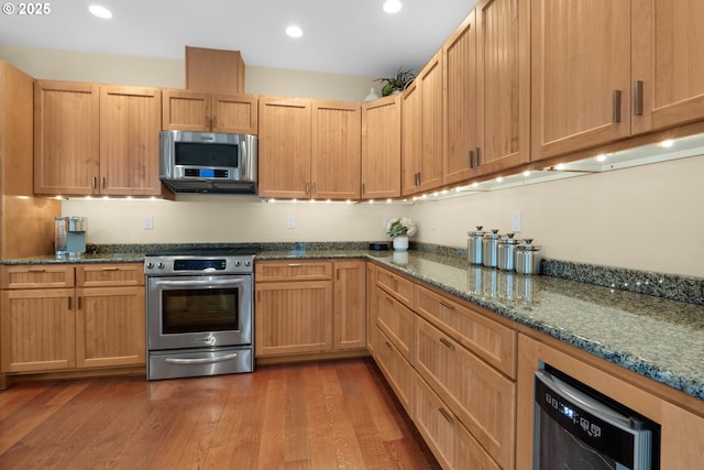 123 S Hemlock St # 201, Cannon Beach, OR 97110 - kitchen with appliances with stainless steel finishes, dark stone counters, dark wood-style flooring, and recessed lighting