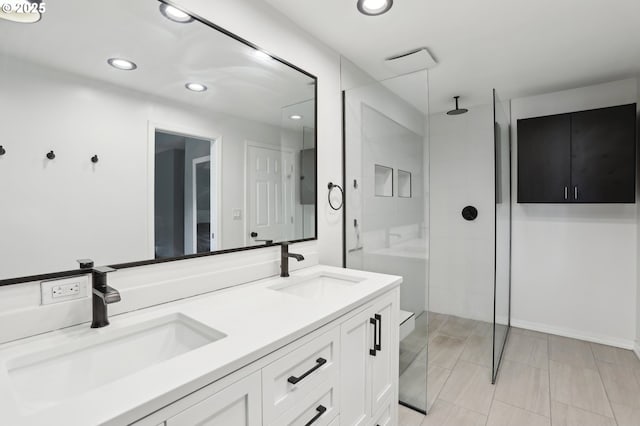 bathroom with a sink, recessed lighting, and a tile shower