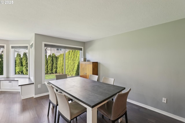 dining area with baseboards, a textured ceiling, and dark wood-style flooring