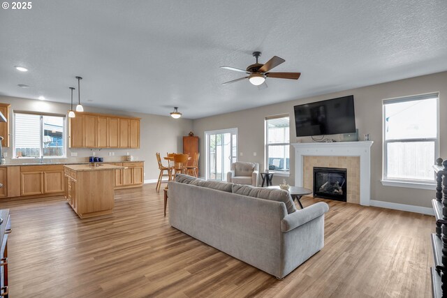 living room featuring ceiling fan, plenty of natural light, sink, and dark hardwood / wood-style flooring