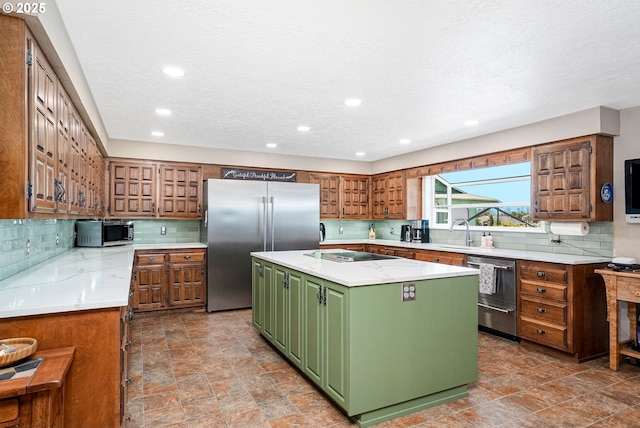41266 Manitau Rd SE, Stayton, OR 97383 - kitchen featuring stainless steel appliances, green cabinetry, a center island with sink, decorative backsplash, and recessed lighting