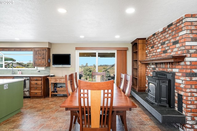 41266 Manitau Rd SE, Stayton, OR 97383 - dining space featuring a textured ceiling, a wood stove, plenty of natural light, recessed lighting, and light stone finish flooring