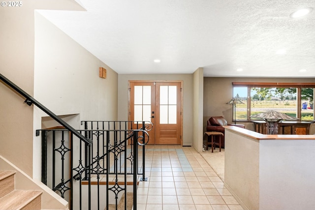 41266 Manitau Rd SE, Stayton, OR 97383 - foyer with french doors, recessed lighting, light tile patterned flooring, stairway, and a textured ceiling