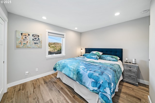 bedroom featuring baseboards, wood finished floors, and recessed lighting