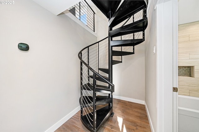 stairway with baseboards and wood finished floors