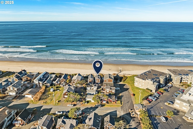 birds eye view of property featuring a beach view, a water view, and a residential view