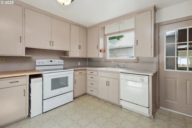kitchen with white appliances, a sink, light countertops, and cream cabinets