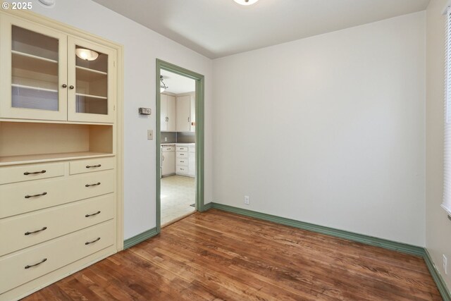 unfurnished bedroom featuring wood finished floors and baseboards