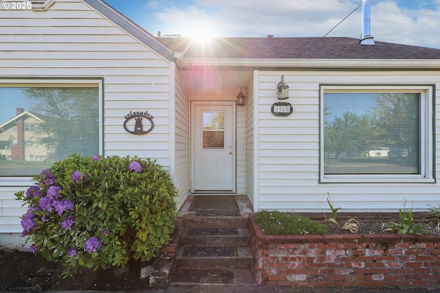 property entrance featuring roof with shingles