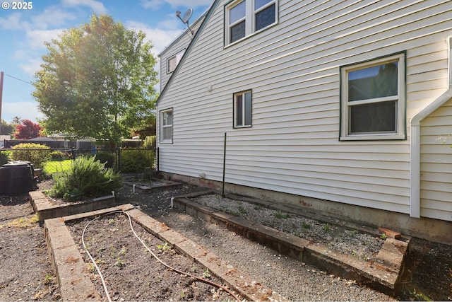 view of side of home featuring a vegetable garden and fence