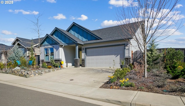 craftsman-style home with a shingled roof, concrete driveway, an attached garage, board and batten siding, and stone siding