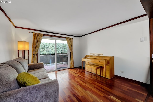 living area featuring ornamental molding, baseboards, and wood finished floors