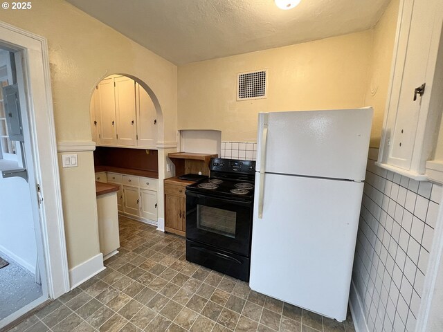 1125 16th St, Astoria, OR 97103 - kitchen featuring freestanding refrigerator, black range with electric cooktop, white cabinetry, tasteful backsplash, and a textured ceiling