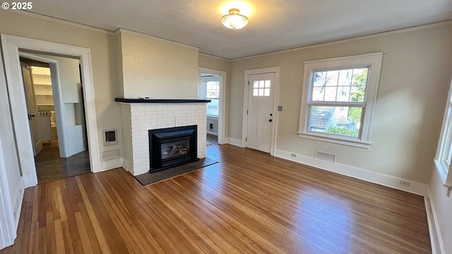 1125 16th St, Astoria, OR 97103 - unfurnished living room with crown molding, wood finished floors, a brick fireplace, heating unit, and baseboards