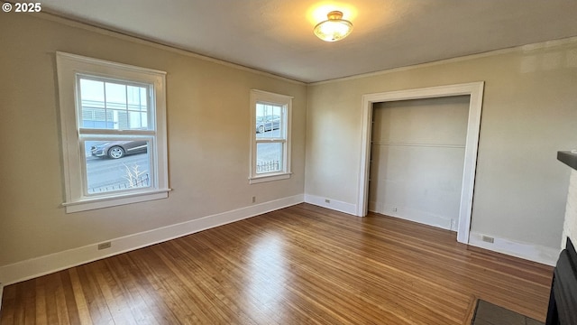 1125 16th St, Astoria, OR 97103 - unfurnished bedroom with ornamental molding, multiple windows, wood finished floors, baseboards, and a closet