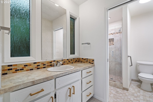 full bathroom featuring tasteful backsplash, toilet, vanity, and a shower stall