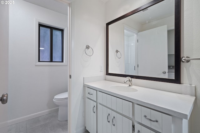 bathroom featuring tile patterned floors, toilet, vanity, and baseboards