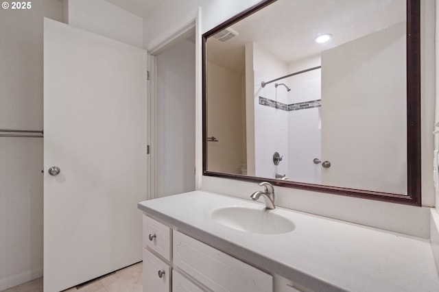 bathroom with vanity, visible vents, and walk in shower