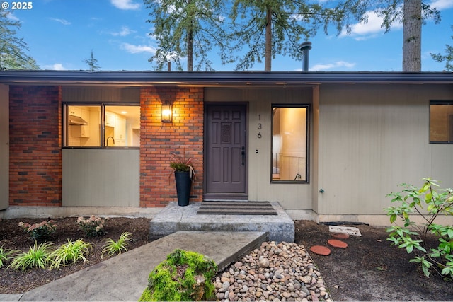 view of exterior entry featuring brick siding