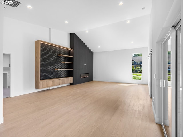unfurnished living room featuring recessed lighting, baseboards, visible vents, vaulted ceiling, and light wood-style floors
