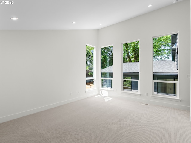 carpeted empty room with recessed lighting, baseboards, a healthy amount of sunlight, and visible vents
