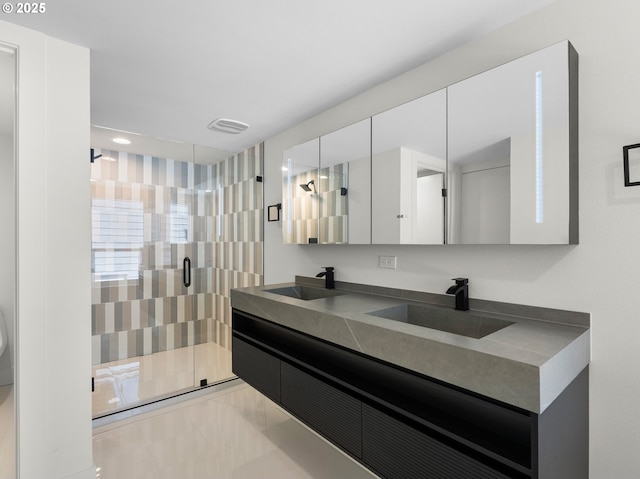 full bathroom featuring a shower stall, recessed lighting, double vanity, and a sink