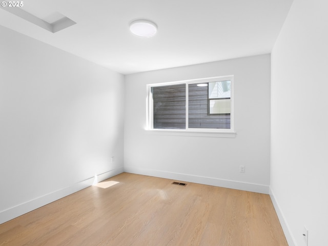 unfurnished room with light wood-type flooring, baseboards, and visible vents
