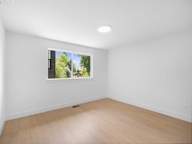 empty room featuring baseboards and light wood-style floors