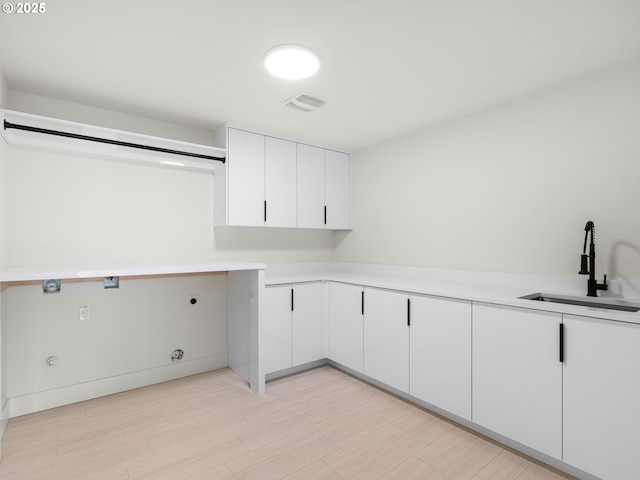 washroom with a sink, cabinet space, visible vents, gas dryer hookup, and electric dryer hookup