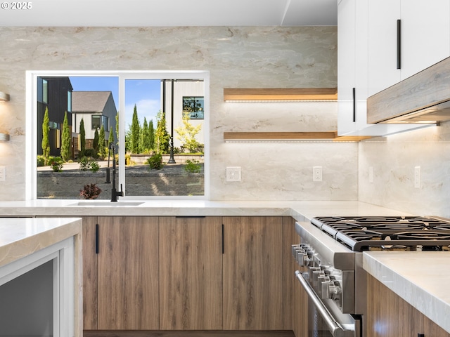 kitchen featuring brown cabinets, modern cabinets, white cabinets, and high end stove