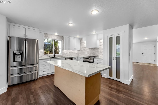 3612 NE 111th St, Vancouver, WA 98686 - kitchen with appliances with stainless steel finishes, decorative backsplash, dark wood-type flooring, a kitchen island, and white cabinets