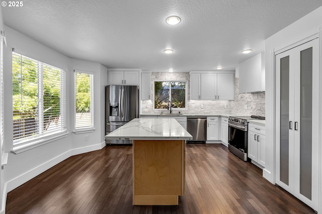 3612 NE 111th St, Vancouver, WA 98686 - kitchen with stainless steel appliances, a center island, backsplash, a sink, and baseboards