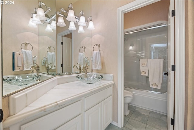 bathroom with toilet, vanity, enclosed tub / shower combo, and tile patterned flooring