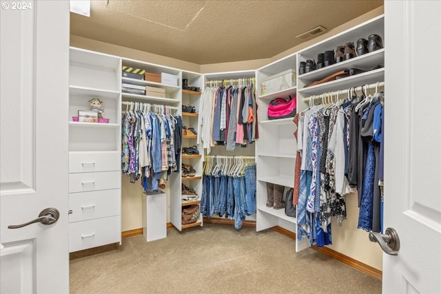 walk in closet featuring carpet flooring