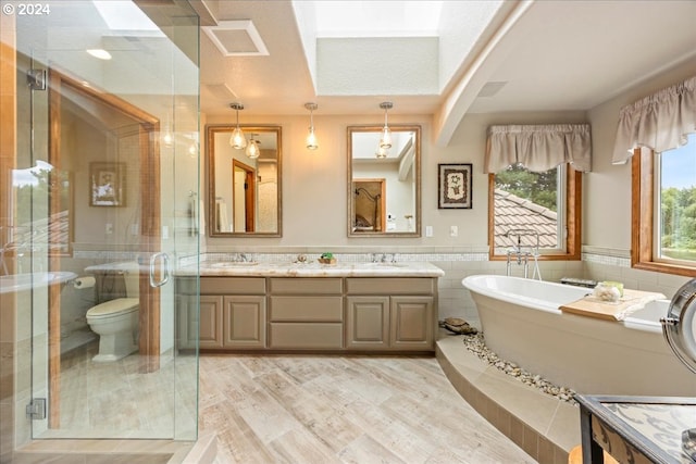 full bathroom featuring tile walls, a stall shower, a soaking tub, double vanity, and a wainscoted wall