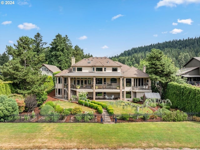 back of property featuring a chimney and a forest view