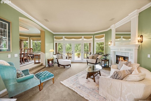 carpeted living room with ornamental molding, a tiled fireplace, and french doors