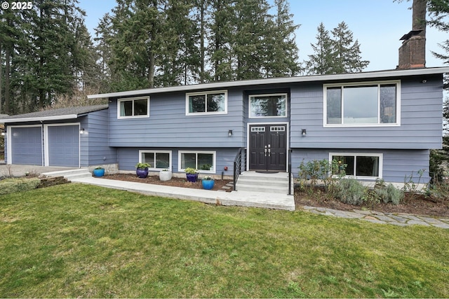 bi-level home featuring a garage and a front lawn