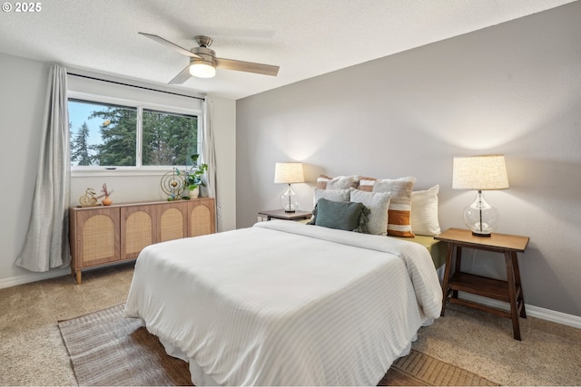 bedroom featuring ceiling fan, light colored carpet, and a textured ceiling