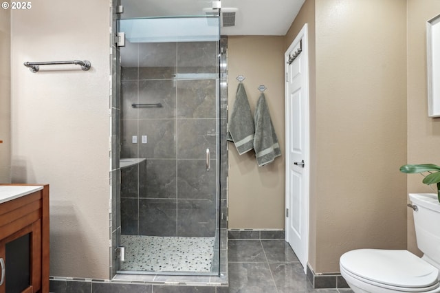 bathroom featuring vanity, tile patterned floors, a shower with door, and toilet