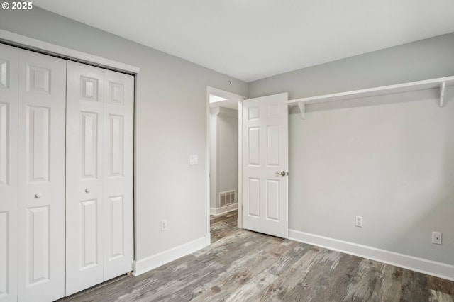 unfurnished bedroom with a closet and light wood-type flooring