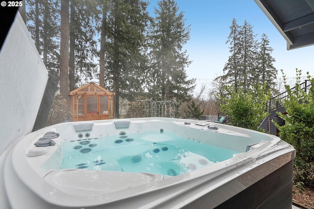 view of pool with a hot tub and an outdoor structure