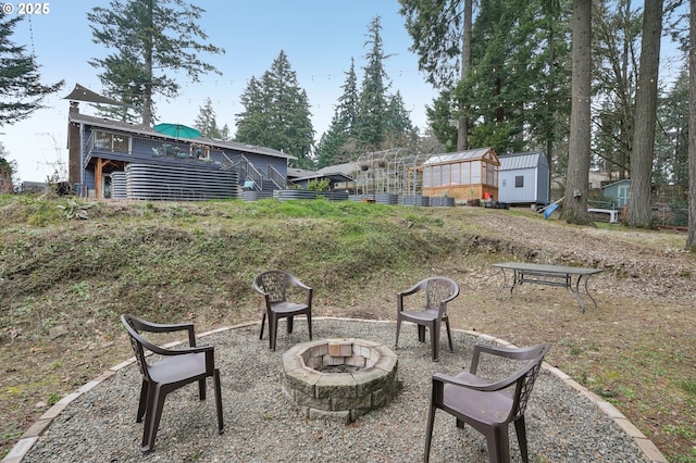 view of yard with an outdoor fire pit and a shed