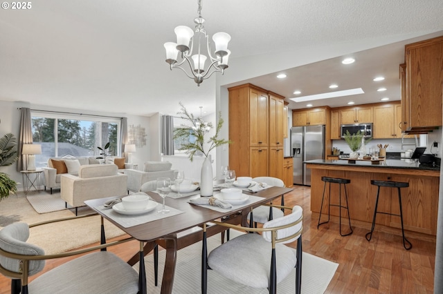 dining area with a notable chandelier and light hardwood / wood-style floors