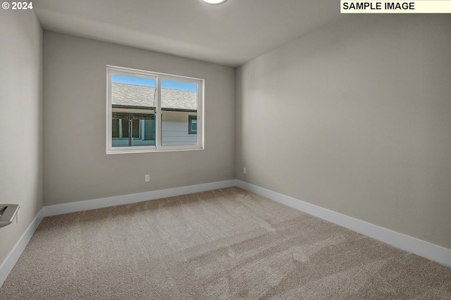 carpeted empty room with baseboards