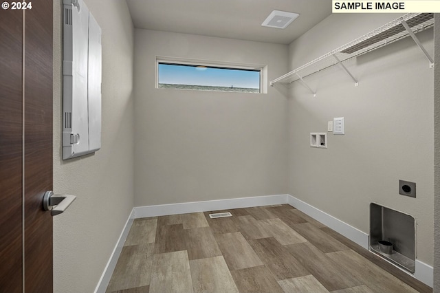 laundry room with hookup for an electric dryer, laundry area, visible vents, baseboards, and light wood finished floors