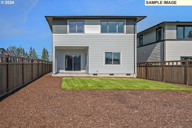 rear view of house featuring a yard and a fenced backyard