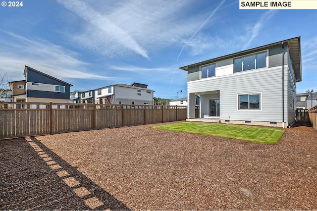 back of house with a fenced backyard and a patio