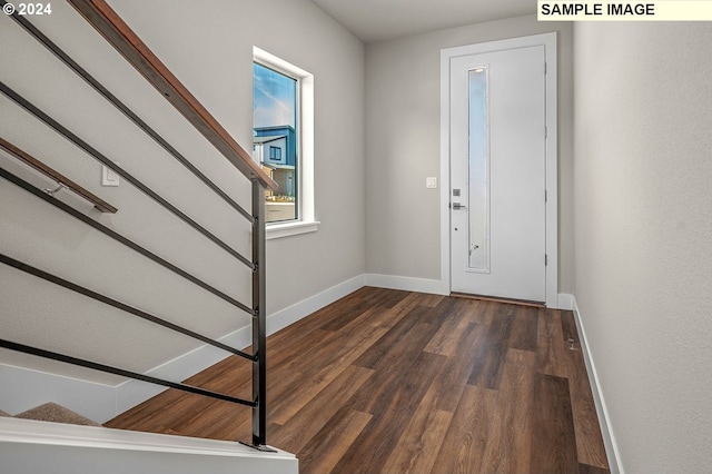 foyer with stairway, dark wood finished floors, and baseboards