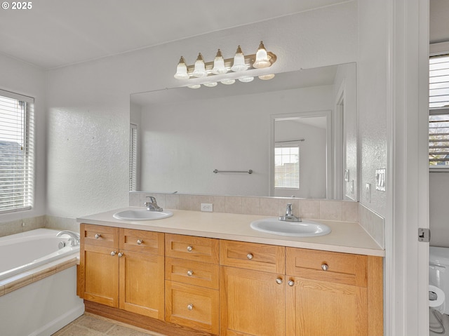 full bathroom featuring a textured wall, a sink, toilet, and double vanity